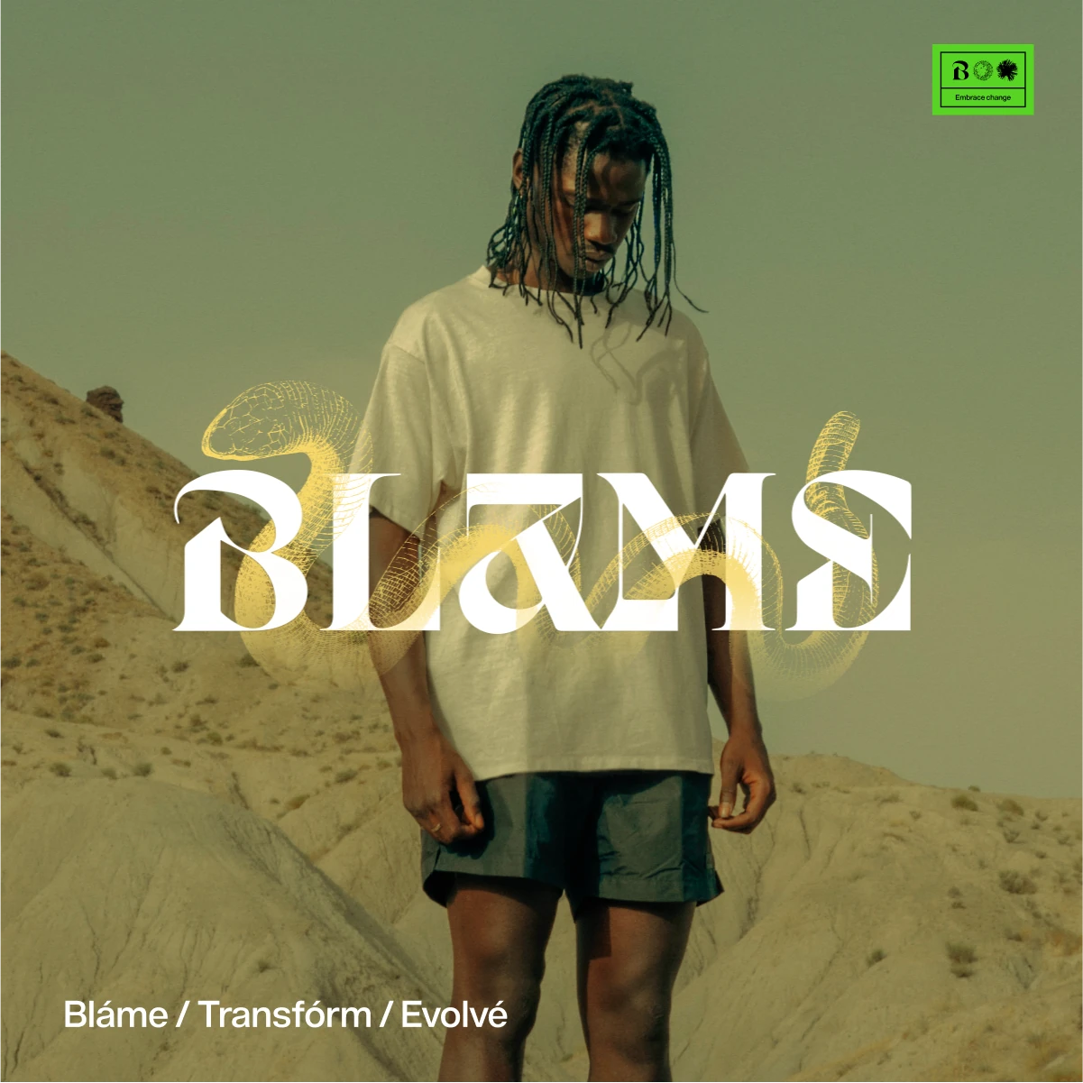 Blame wordmark in white over a model in a white t-shirt standing in desert hills