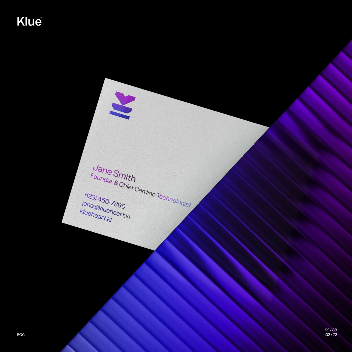 Klue business card with the logo in violet, lying on dark glass planes