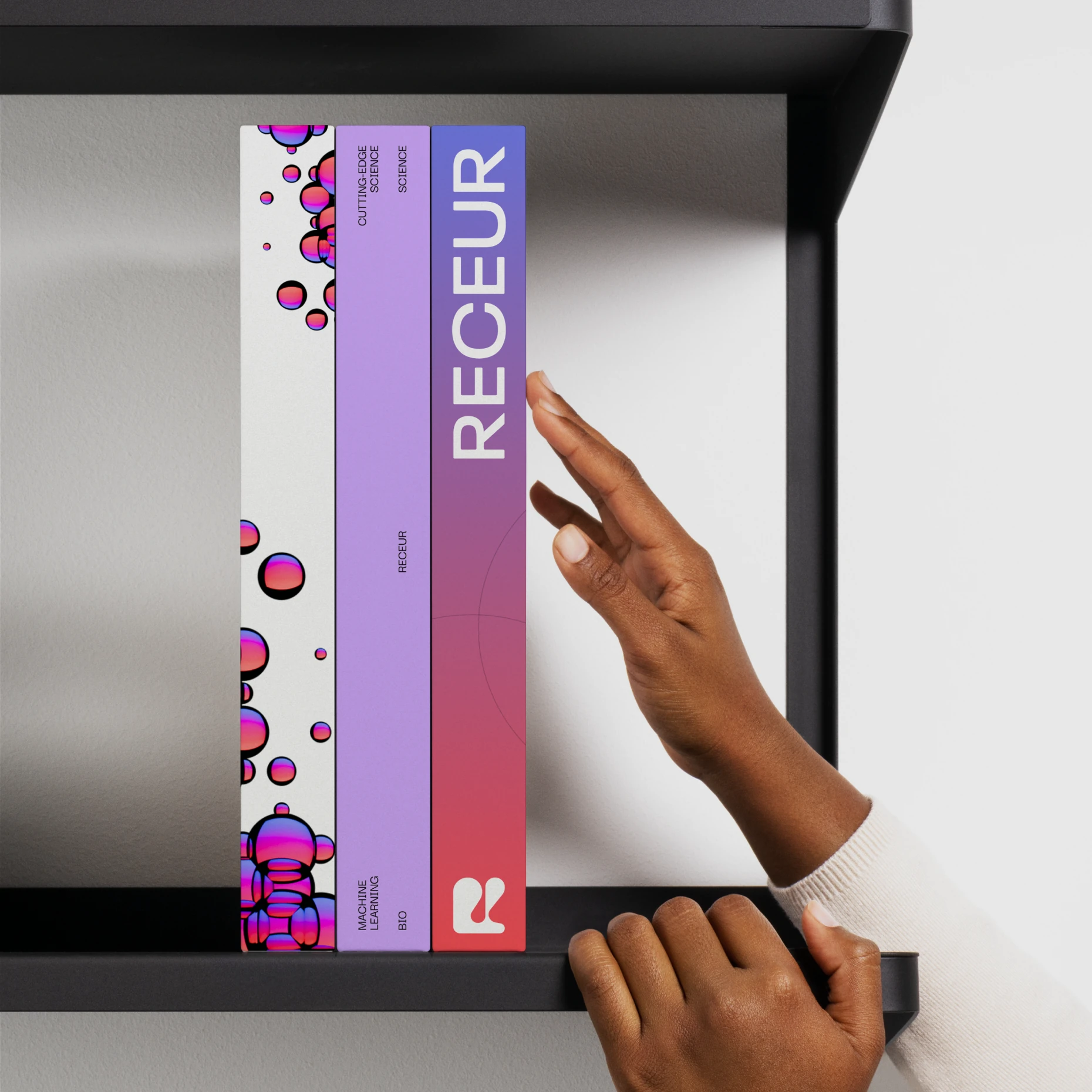 Hand taking Receur journals with cell sphere covers from a shelf