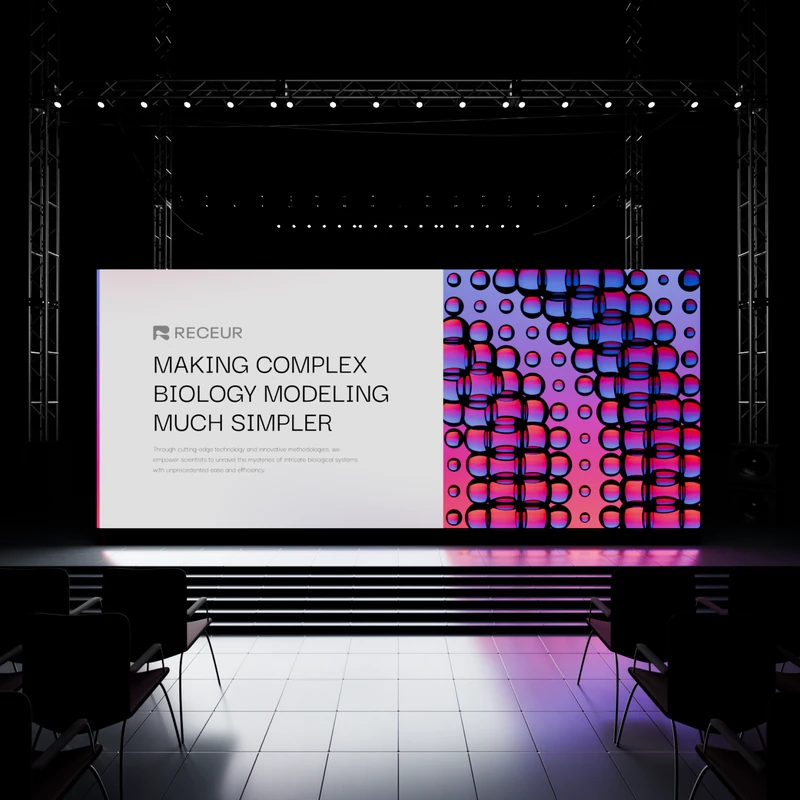 Stage screen reading Receur, Making Complex Biology Modeling Much Simpler, beside glossy cell spheres